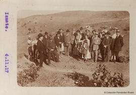 Iznate (Málaga), retrato de un grupo de excursionistas y una mula en los alrededores del pueblo junto a una viña. Fotógrafo desconocido.