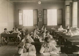 España, aula de una escuela infantil con los niños estudiando en sus pupitres. Fotógrafo desconocido.