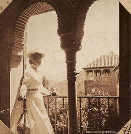 Granada, Alhambra, una turista en el ajimez del Salón de Embajadores. Fotógrafo desconocido.