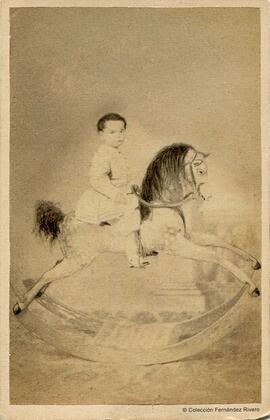 Córdoba, retrato de un niño en un caballito de cartón con balancín. Widen.
