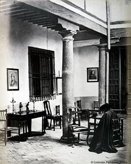 Toledo, patio porticado de una casa manchega, personaje con capa y muebles tradicionales. J. Laurent y Cia.