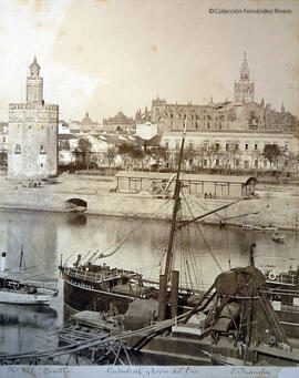Sevilla, a Torre del Oro y la Catedral desde la orilla derecha del Guadalquivir con barcos en primer plano. E. Beauchy.