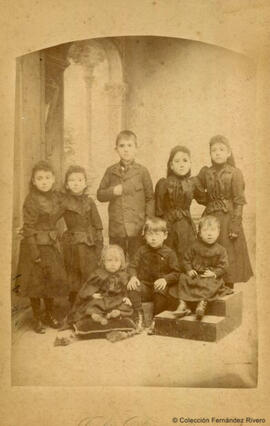 Retrato de un grupo de ocho niños y niñas, todos vestidos de negro. Julio Derrey.