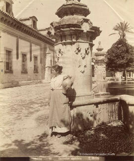 Córdoba, Mezquita, Patio de los Naranjos, una joven con un cántaro junto a la Fuente de Santa María. Tomás Molina.
