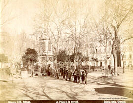 Málaga, Plaza de la Merced, grupo de transeuntes ante el monumento al General Torrijos. Garzón.