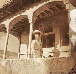 Granada, Patio de los Arrayanes, una turista posa en la parte superior de la Torre del Peinador de la Reina. Fotógrafo desconocido.