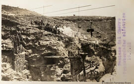 Ardales (Málaga), construcción de la presa sobre el río Guadalhorce, "transbordador eléctrico" observado por un grupo de excursionistas. Fotógrafo desconocido.